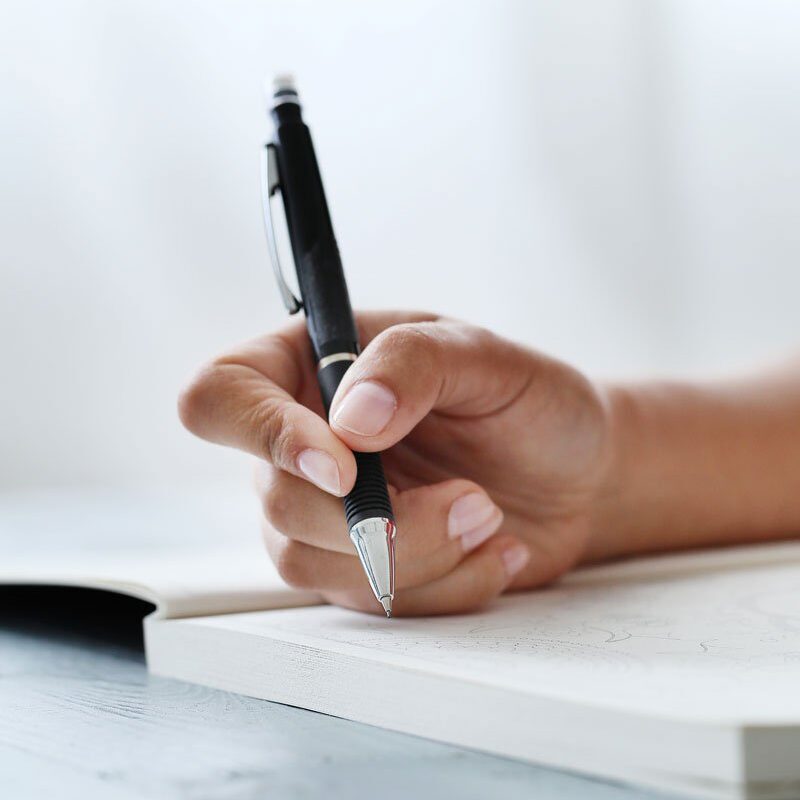 Woman holding pen, preparing to write.